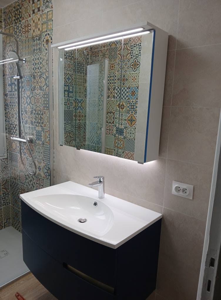 Salle de bains rénovée : meuble vasque, miroir lumineux et carrelage à motifs